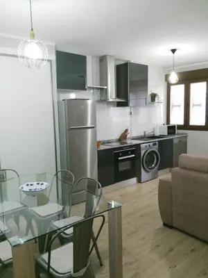 a kitchen and living room with a table and a dining room at La Guariza in Villablino