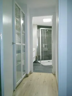 a hallway with a walk in shower and a glass door at La Guariza in Villablino