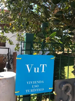 a blue sign that reads vut under a tree at Chalet xeitosiño in Astorga