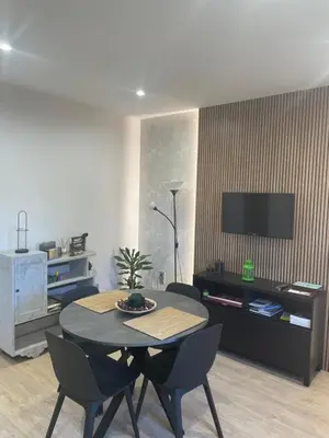 a living room with a table and chairs and a tv at Chalet xeitosiño in Astorga