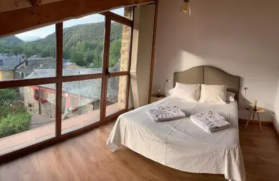 a bedroom with a bed and a large window at La casa de Lucas y Alex in Ponferrada