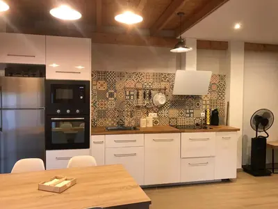 a kitchen with white appliances and a wooden table at La casa de Lucas y Alex in Ponferrada