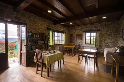 a dining room with tables and chairs in a stone building at O Canto da Terra in Pantón
