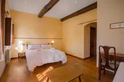 a bedroom with a white bed and a table at O Canto da Terra in Pantón