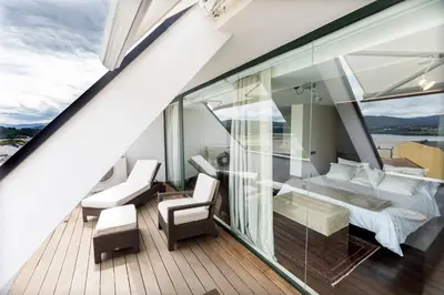 a room with a balcony with a bed and chairs at Exclusiva vivienda de lujo in Foz