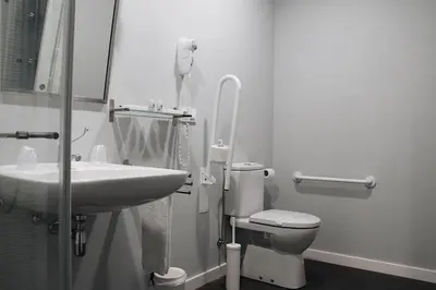 a bathroom with a sink and a toilet and a mirror at Casa Costoya in Arzúa