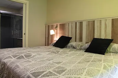 a bedroom with a large bed with two pillows at Casa Costoya in Arzúa
