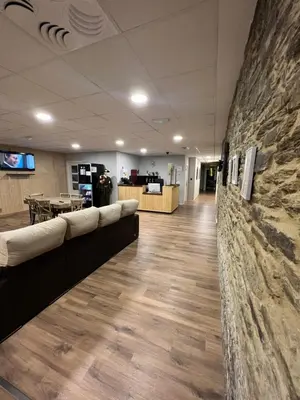 a lobby with couches and a stone wall at Casa Costoya in Arzúa