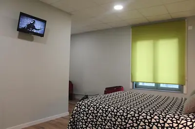a bedroom with a bed and a green window at Casa Costoya in Arzúa
