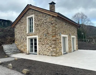 a small brick building with two windows and stairs at Casa Rural As Bodegas - Villa Rustica Asturias - Boal in Boal