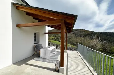 a wooden deck with a pergola on a house at Casa Rural As Bodegas - Villa Rustica Asturias - Boal in Boal