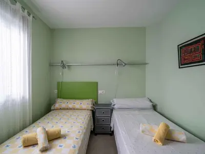 two twin beds in a room with green walls at Apartment Edificio Bahia II by Interhome in Miño