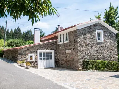 a stone house with a white garage at Holiday Home El Olivo by Interhome in Puentedeume