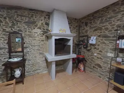 a living room with a stone wall with a fireplace at Holiday Home El Olivo by Interhome in Puentedeume