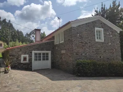 a stone house with a white garage at Holiday Home El Olivo by Interhome in Puentedeume