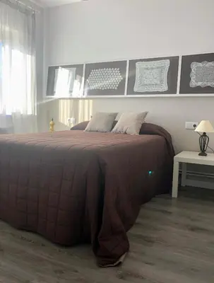 a bedroom with a large bed with a brown blanket at La Barranca in Barreiros