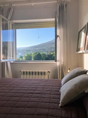 a bedroom with a large window and a bed with pillows at La Barranca in Barreiros