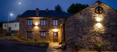 a stone house with lights on it at night at Casa da Lembranza in Fonsagrada