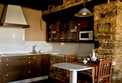 a kitchen with a table and a sink and a microwave at Casa da Lembranza in Fonsagrada
