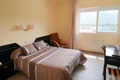 a hotel room with a bed and a window at Hospedaje O Camiño in O Barco de Valdeorras