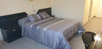 a bedroom with a bed and a chair in a room at Hospedaje O Camiño in O Barco de Valdeorras