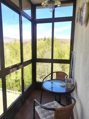 a table and chairs in a room with a large window at DÚPLEX SANABRIA in El Puente