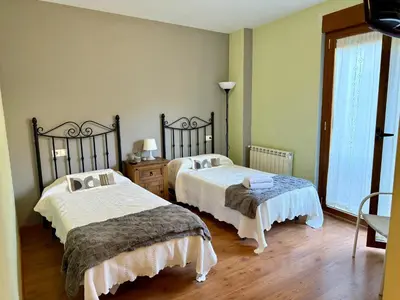 a bedroom with a bed and a large window at Hostal El Horno in Molinaseca