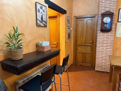 a room with a fireplace and a door and a table and chairs at Hostal El Horno in Molinaseca