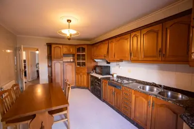 a kitchen with wooden cabinets and a wooden table at Vieiro Verde in Vieiro