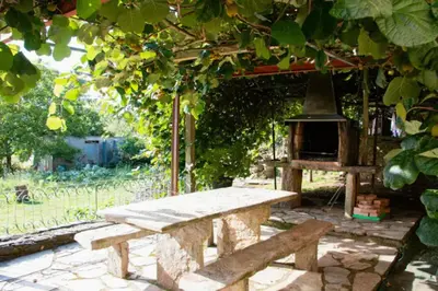 a stone bench in a garden with an outdoor oven at Vieiro Verde in Vieiro