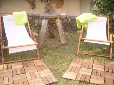 a wooden chair sitting on a porch at Apartamentos Rurales Buenamadre in Pola de Somiedo