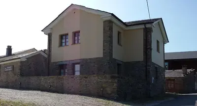 an old brick building with windows on the side of it at Apartamentos Rurales Casanova in Tapia de Casariego