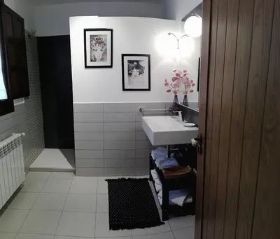 a bathroom with a sink and a white tiled wall at Apartamentos Rurales Casanova in Tapia de Casariego