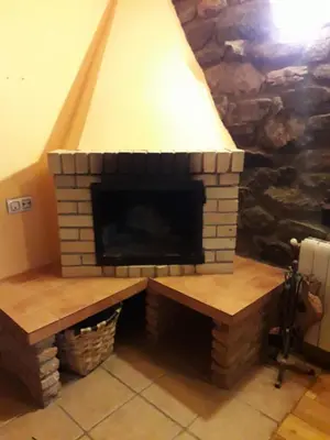 a brick fireplace in a living room at Casa Serafo in Saliencia