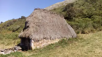 a hut with a grass roof on a hill at Casa Serafo in Saliencia