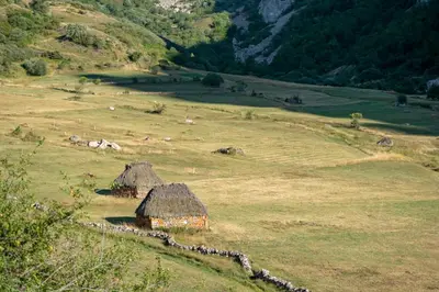 a field with a group of huts on a hill at Casa Serafo in Saliencia