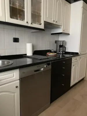 a kitchen with white cabinets and a black counter top at Oktheway Praza Galicia in Sarria