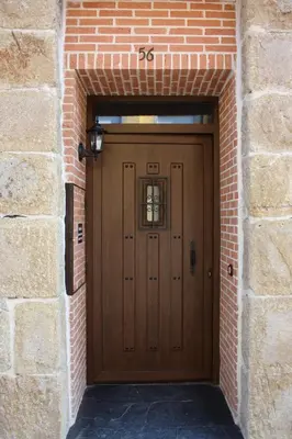 a large wooden door in a brick wall at Casa Rural El Almendro De Maria in Ponferrada