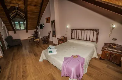 a bedroom with a large bed and a wooden floor at Casa Rural El Almendro De Maria in Ponferrada