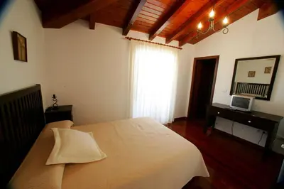 a bedroom with a white bed and a window at Casa da Botica A Estrada in Os Casares