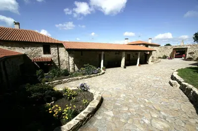 a courtyard of a house with a stone driveway at Casa da Botica A Estrada in Os Casares