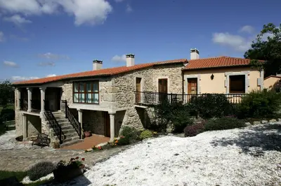 a stone house with a staircase in front of it at Casa da Botica A Estrada in Os Casares
