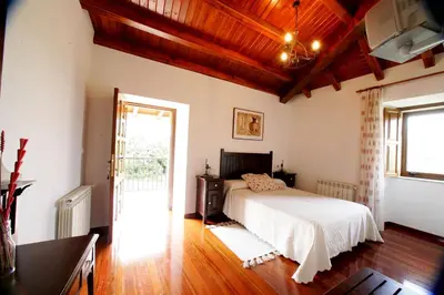 a bedroom with a white bed and a window at Casa da Botica A Estrada in Os Casares