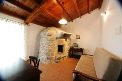 a living room with a stone fireplace in a house at Casa da Botica A Estrada in Os Casares