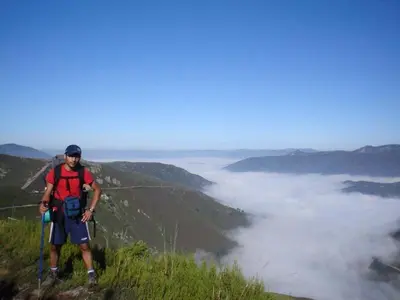 a man is standing on top of a mountain at Hotel Nueva Allandesa in Pola de Allande
