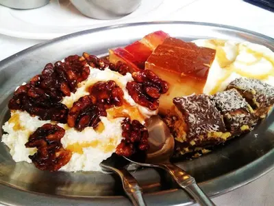 a plate of desserts on a table with a spoon at Hotel Nueva Allandesa in Pola de Allande