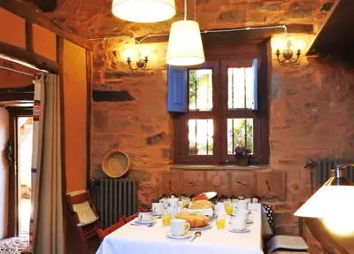 a table in a restaurant with a white table cloth at La Casa De Murias in Murias de Rechivaldo