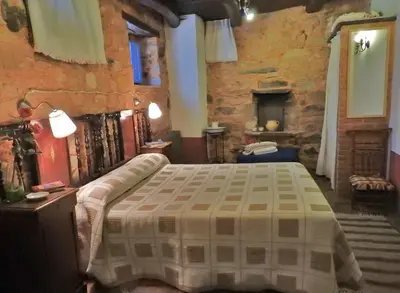 a bedroom with a bed and a stone wall at La Casa De Murias in Murias de Rechivaldo