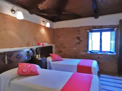 a room with two beds and a window at La Casa De Murias in Murias de Rechivaldo