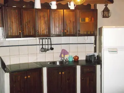 a kitchen with wooden cabinets and a sink and a refrigerator at Carriles Romanos in Odollo